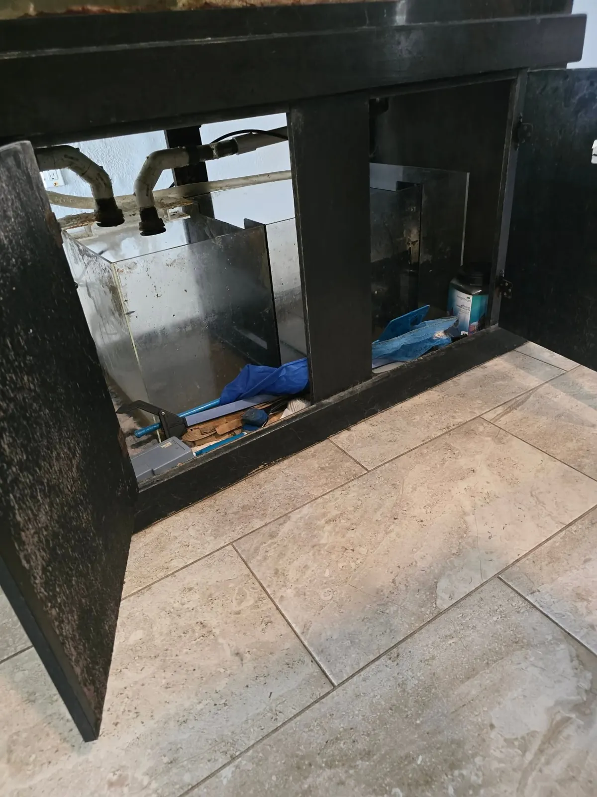 Sump filtration inside an open aquarium cabinet